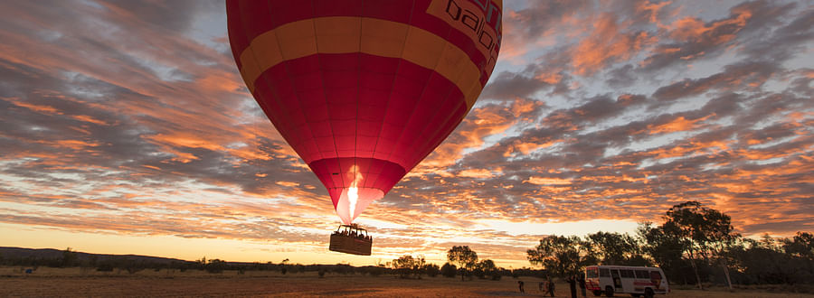 Colorful hot air balloons floating over the desert landscape of Alice Springs